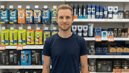 Jeroen staat voor het scheer assortiment in een winkel, in de achtergrond zie je gillette en oneblade scheermesjes, maar ook baard verzoring producten.